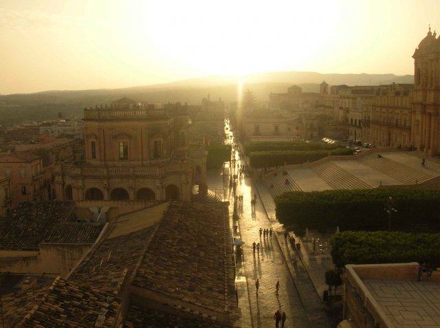 soleil se couchant sur la promenade d'une ville baroque de Sicile